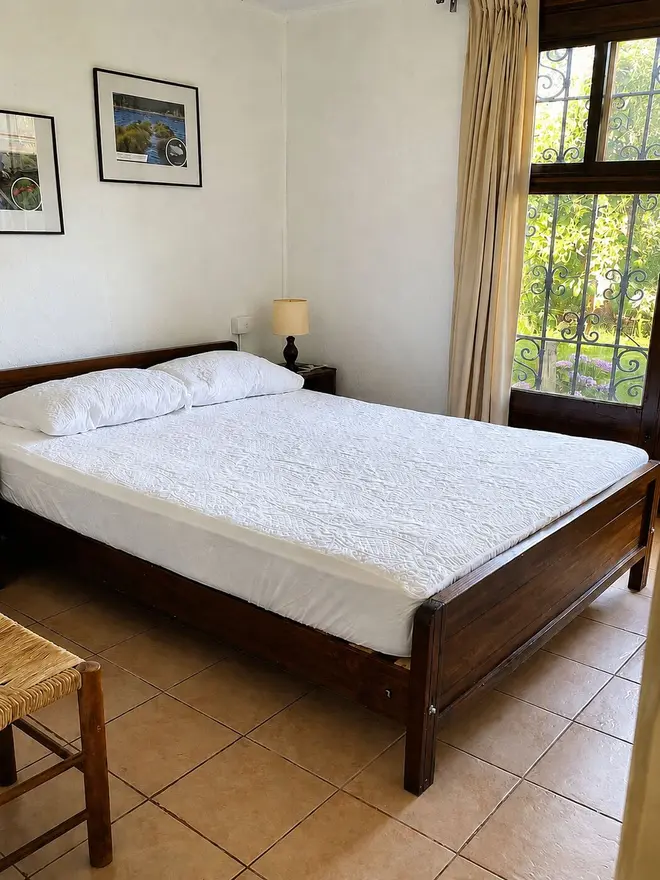 Dormitorio matrimonial con ventana al jardín
