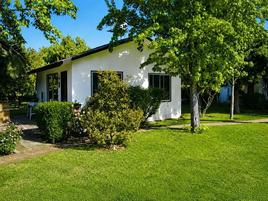 Fachada de cabaña con jardín florido
