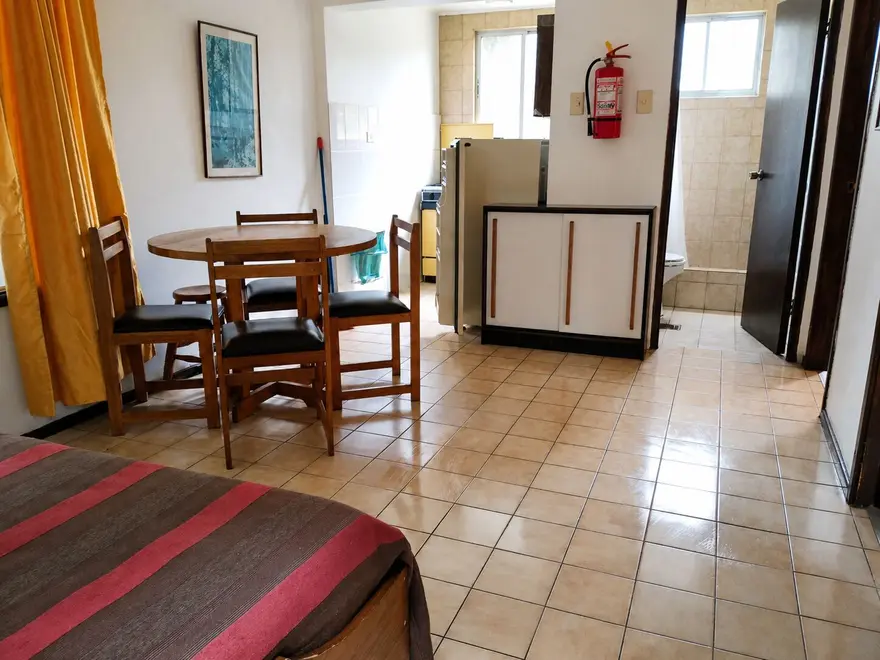 Living con mesa y kitchenette equipada