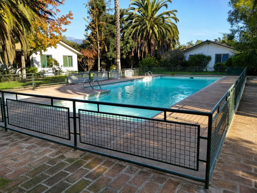Piscina con cerco de malla y palmeras