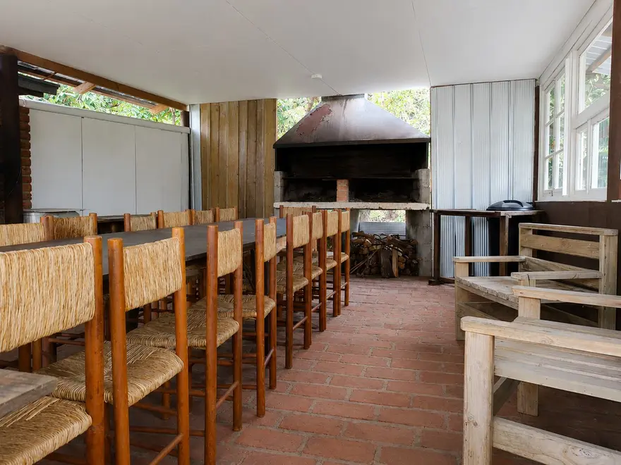Mesa larga con sillas junto al asador