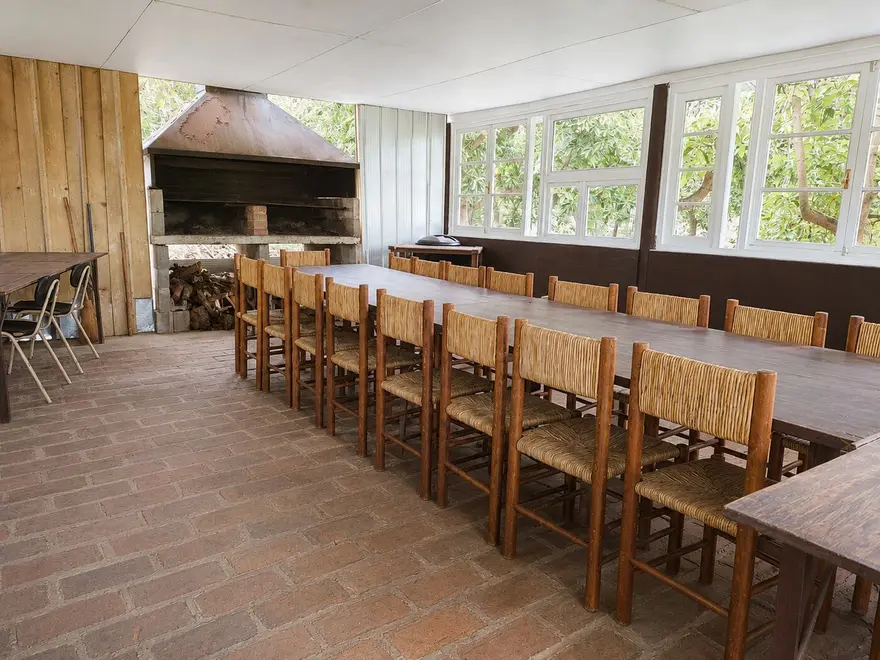 Mesa larga bajo techo, junto al asador